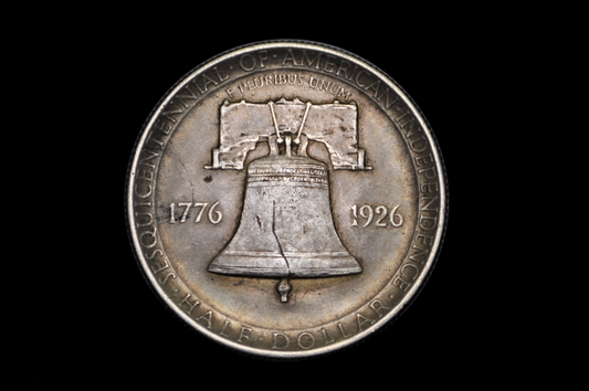 Silver coin with Liberty Bell design and text on a black background