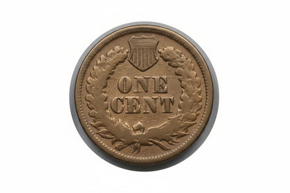 Gold-colored 'ONE CENT' coin with a shield emblem on a gray background