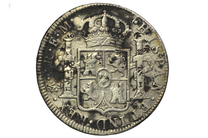 Reverse of a panish 8 reales from 1784. Two pillars on either side of a crest that is topped by a crown above. Lettering: Mo.8R.F.M. Hispan. ET IND.REX