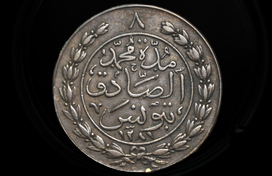 Large Copper coin with Arabic text and floral design on a black background. Tunisia Coin 8 Kharub from 1865
