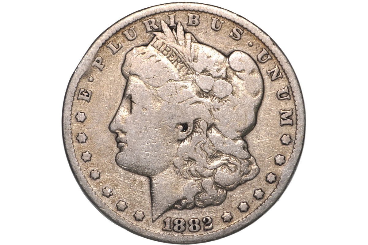 An 1882 Morgan Dollar silver coin inside a clear plastic protective holder, shown in a close-up studio shot.