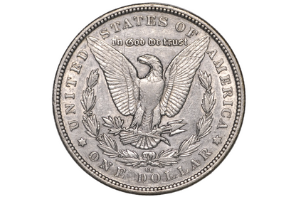 A silver US one dollar coin featuring an eagle and laurel wreath, and the cc mint mark for the Carson City mint. 
