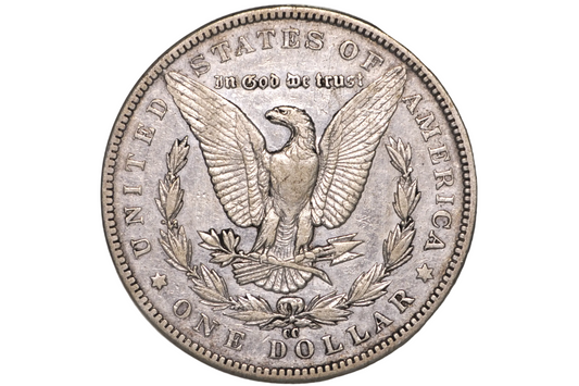 A silver United States one dollar coin featuring an eagle with outstretched wings, surrounded by the text 'IN GOD WE TRUST' and 'UNITED STATES OF AMERICA' and 'ONE DOLLAR', displayed inside a clear plastic protective capsule.