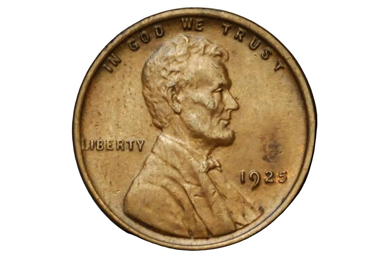 Close-up of a 1925 penny with 'In God We Trust' and 'Liberty' inscriptions on a black background.