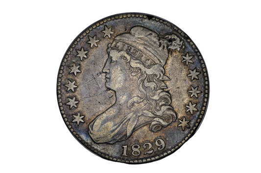 Vintage silver coin with a profile of a person and the year 1829 on a black background