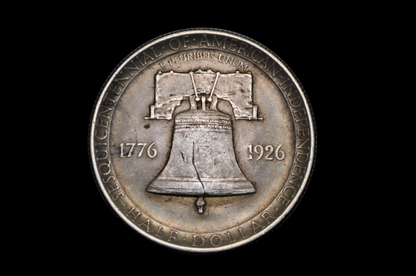Silver coin with Liberty Bell design and text on a black background