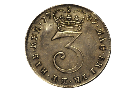 1739 three pence coin from the united kingdom. Vintage coin with a number '3' and crown design on a white background