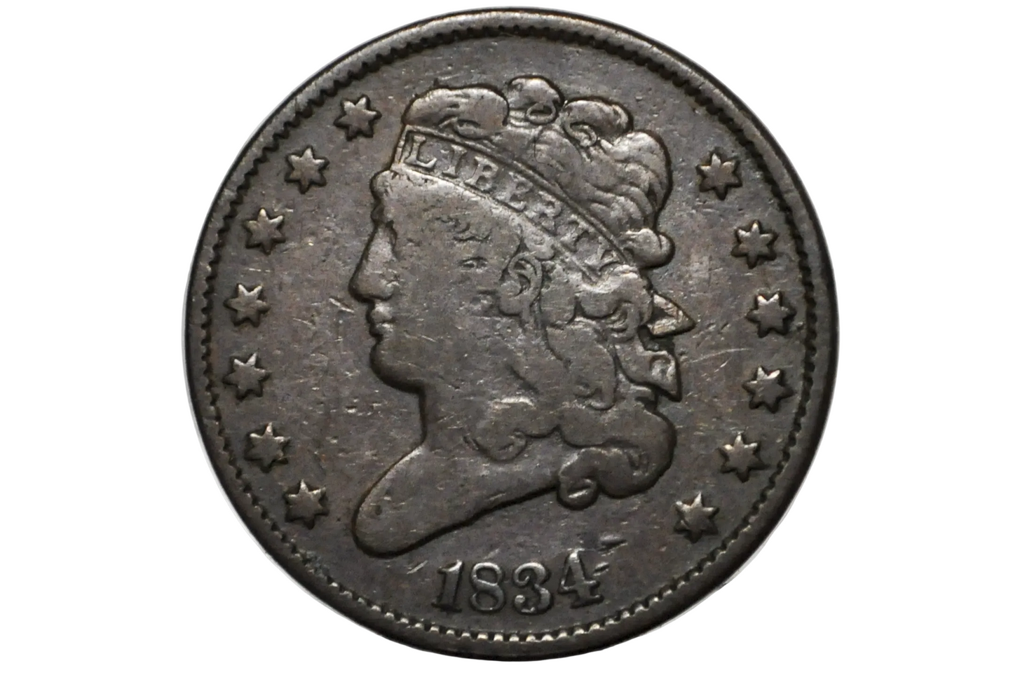 An antique 1834 United States coin featuring a left-facing profile of Liberty with a crown, surrounded by thirteen stars, displayed inside a clear plastic grading holder.