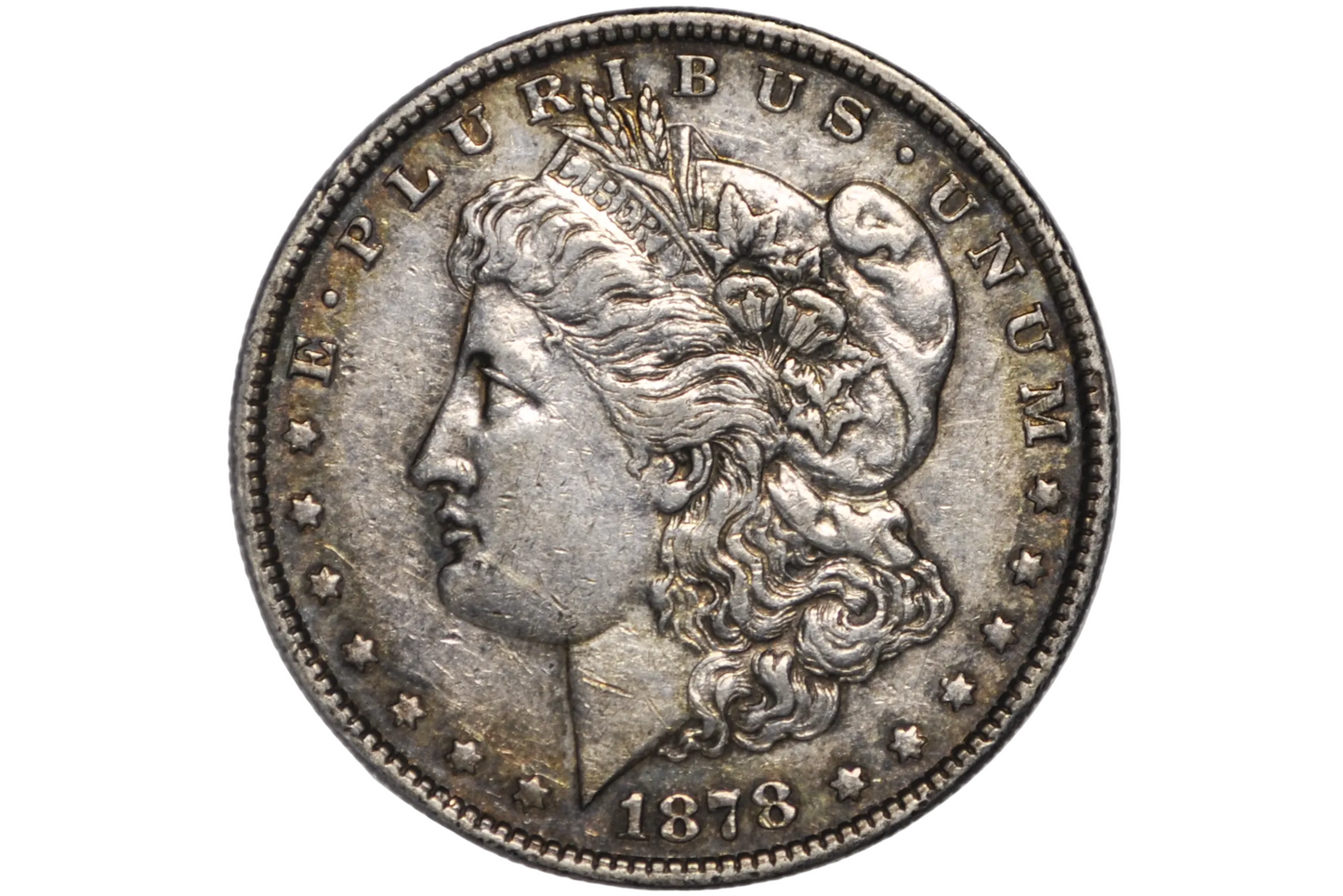 An 1878 Morgan silver dollar coin inside a clear plastic protective capsule, showing the detailed profile of Liberty with the inscription 'E PLURIBUS'.