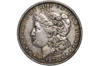 An 1878 Morgan silver dollar coin inside a clear plastic protective capsule, showing the detailed profile of Liberty with the inscription 'E PLURIBUS'.