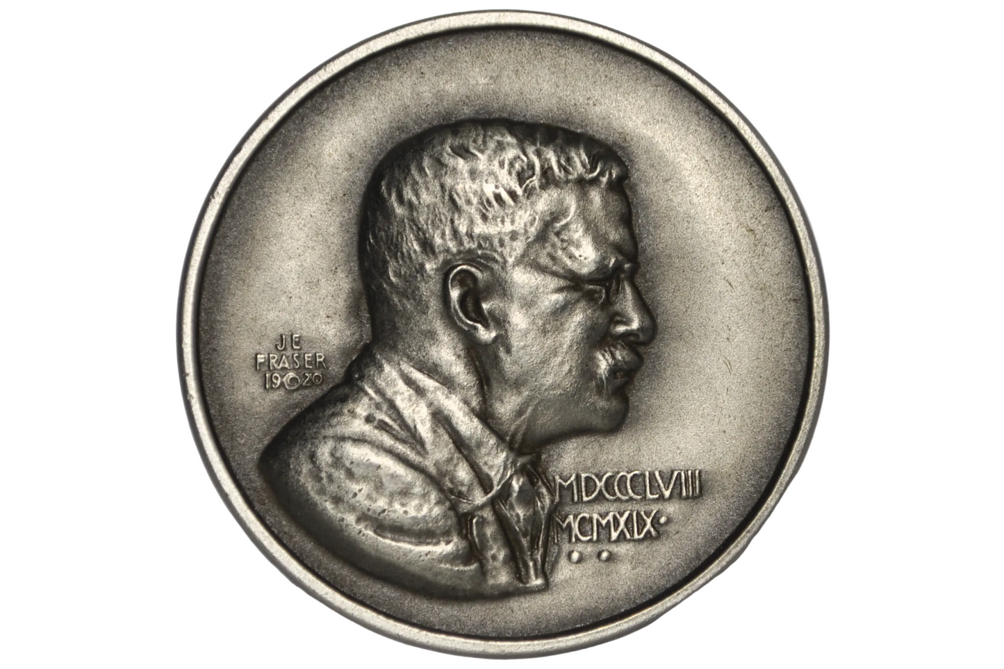 A silver-toned commemorative coin featuring a profile bust of Theodore Roosevelt, displayed inside a clear plastic protective capsule on a light gray background.