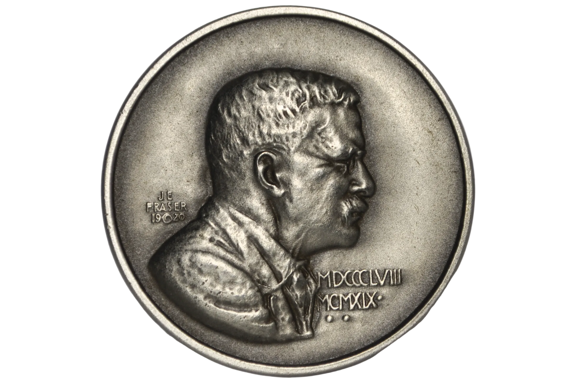 A silver-toned commemorative coin featuring a profile bust of Theodore Roosevelt, displayed inside a clear plastic protective capsule on a light gray background.