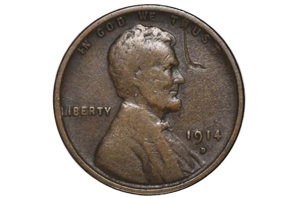 A 1914 D US penny coin showing the Abraham Lincoln profile with 'IN GOD WE TRUST' and 'LIBERTY' inscriptions.